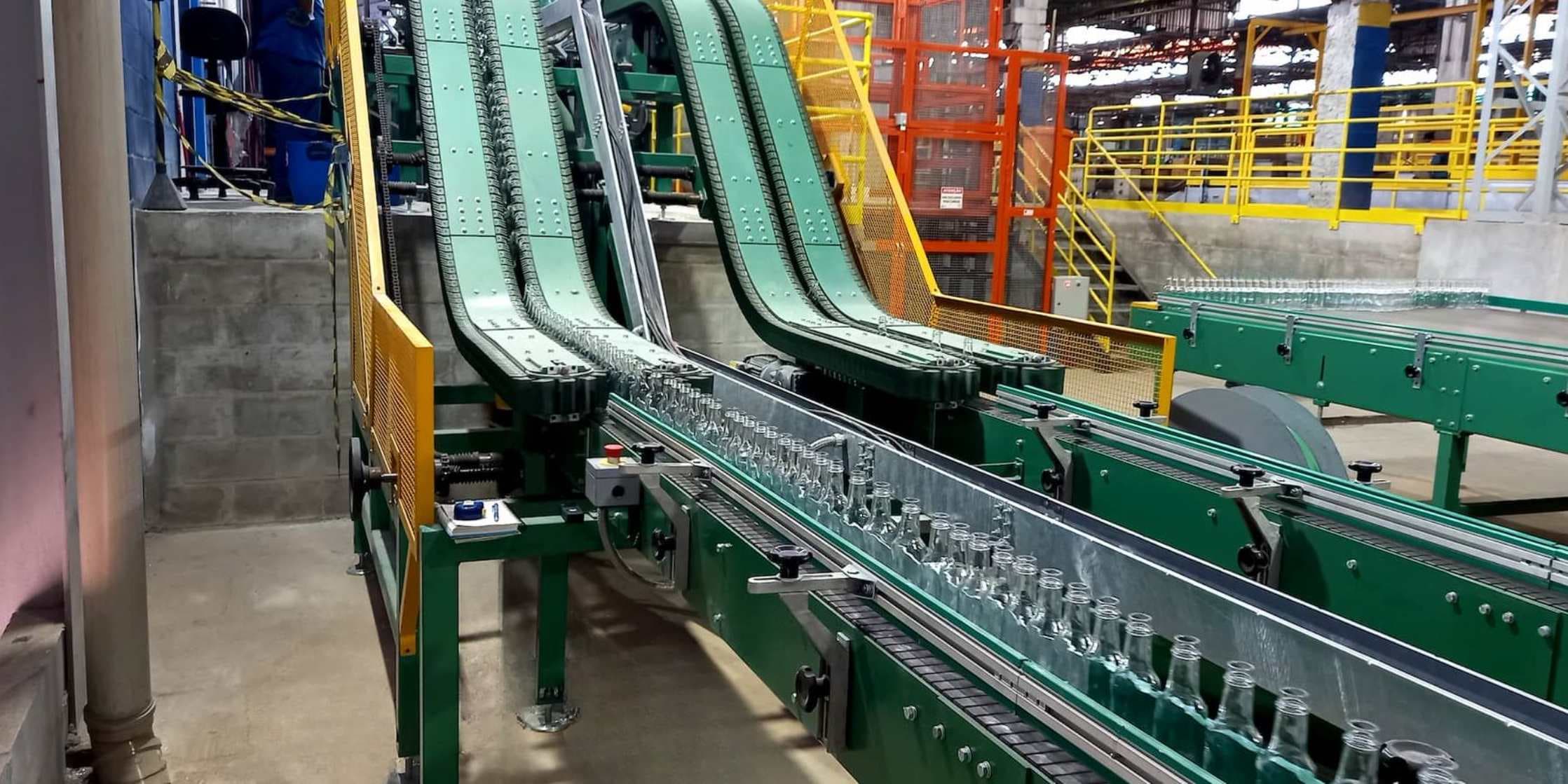 Linha de envase com esteiras e garrafas em produção industrial